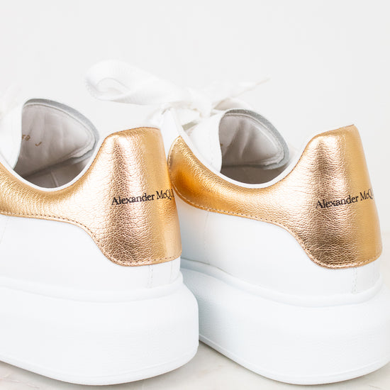 White sneakers with gold accents on a light background