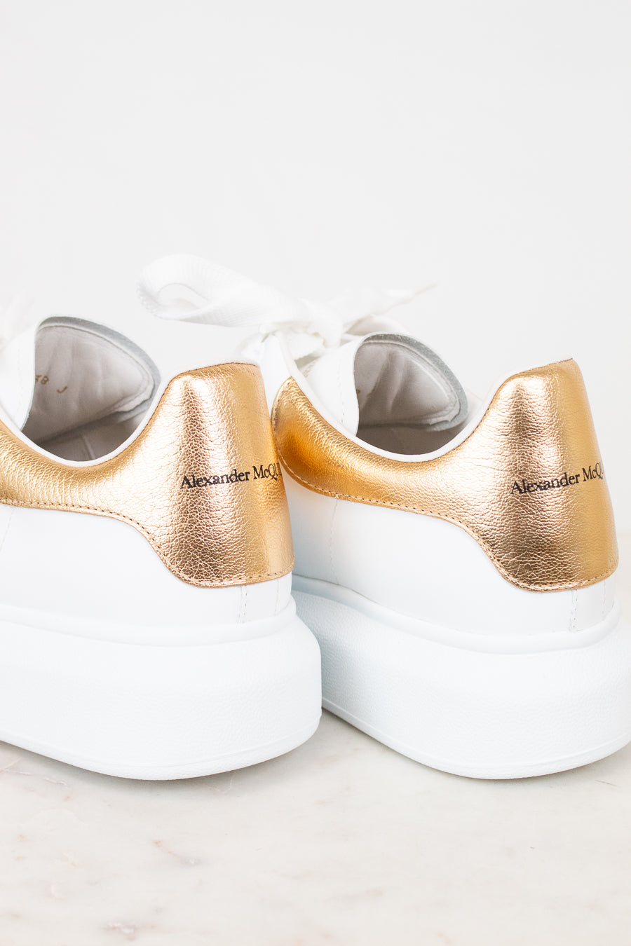 White sneakers with gold accents on a light background