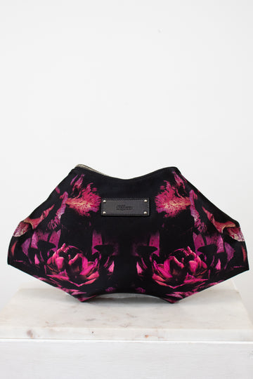 Black and pink floral patterned clutch bag on a white background