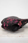 Black and pink floral-patterned purse on a white surface