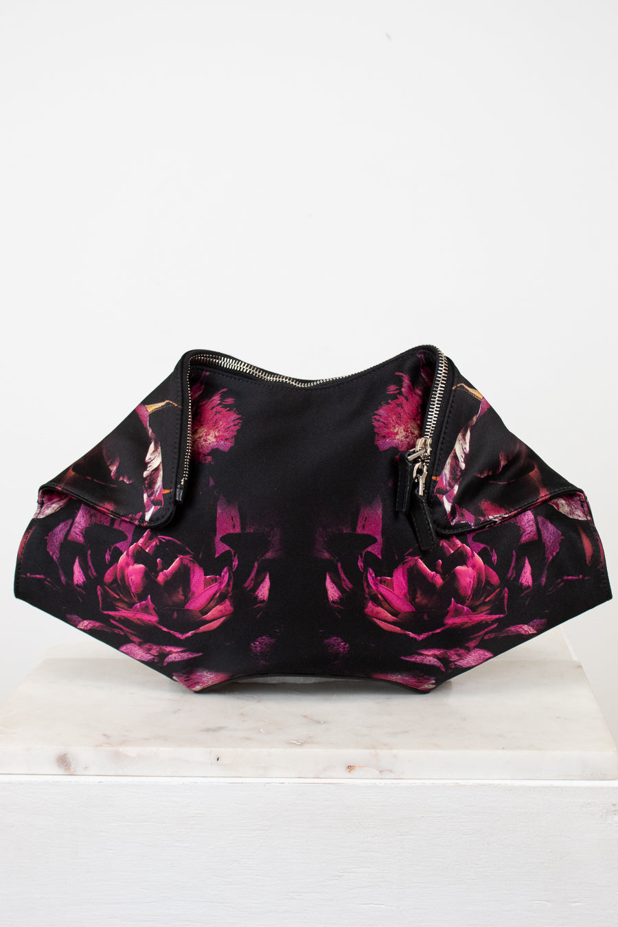 Black clutch with pink floral pattern on a white background
