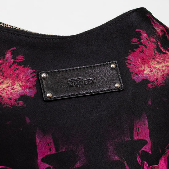 Black bag with pink floral pattern and brand logo on a white background