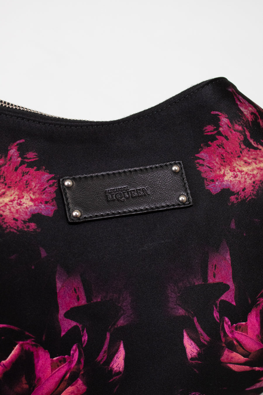 Black bag with pink floral pattern and brand logo on a white background