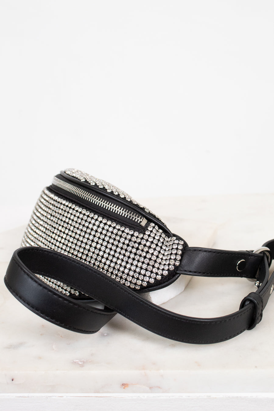Black studded waist bag with a leather strap on a white background
