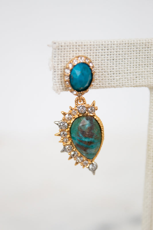 Gold earrings with turquoise stones on a white background