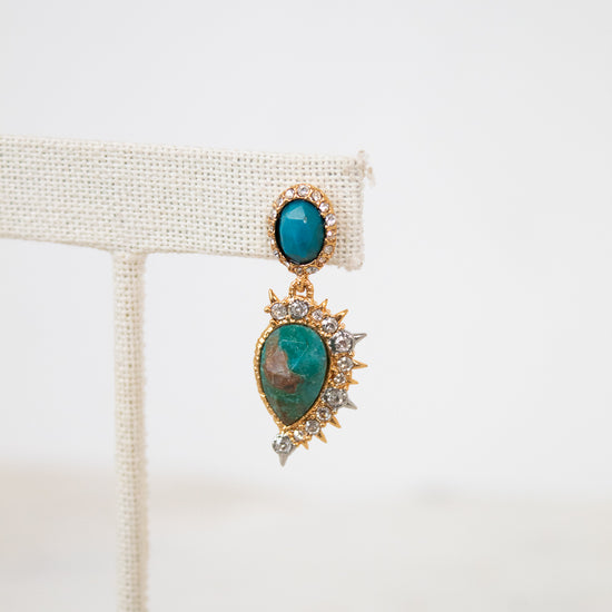 Gold earrings with turquoise stones on a white background