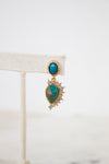 Gold earrings with turquoise stones on a white background
