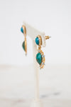 Pair of earrings with turquoise stones and gold accents on a white background