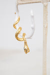 Gold snake-shaped earring on a white background