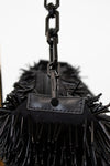 Black spiked handbag with a chain detail on a white background