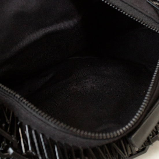 Black fringe clutch bag held open to show interior.