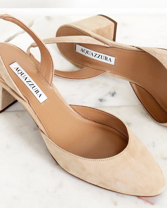 Beige high-heeled shoes with Aquazzura label on a marble surface