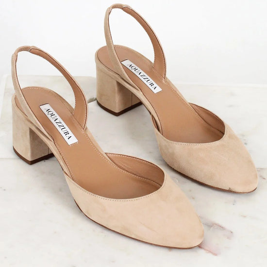 Pair of beige high-heeled shoes with 'Manolo Blahnik' label on a white background