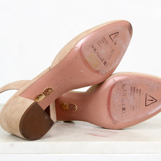 Close-up of pink sole of shoes with gold accents on a white background