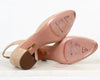 Close-up of pink sole of shoes with gold accents on a white background