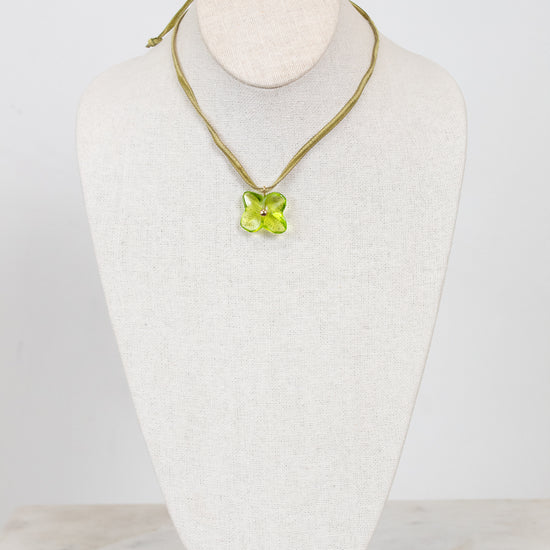 Choker necklace with a green pendant on a mannequin bust against a white background