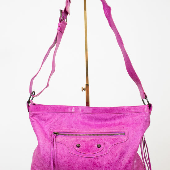 Pink handbag with a strap on a white background