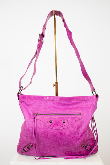Pink handbag with a strap on a white background