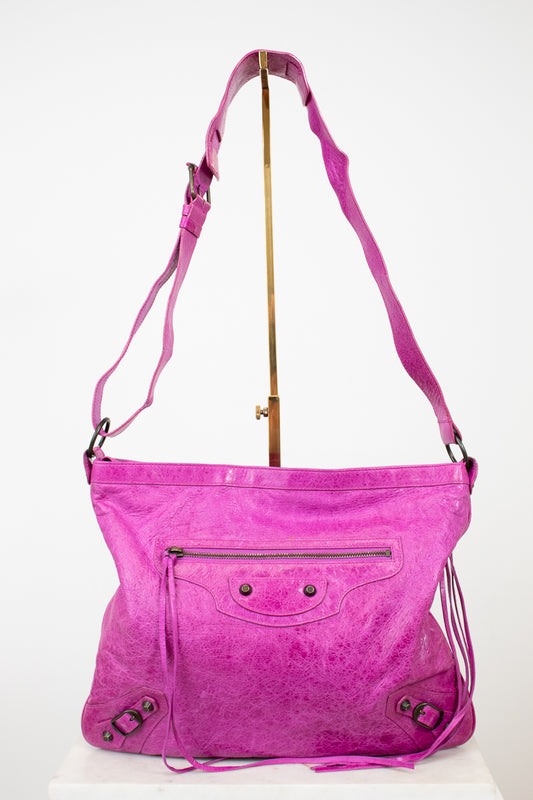 Pink handbag with a strap on a white background