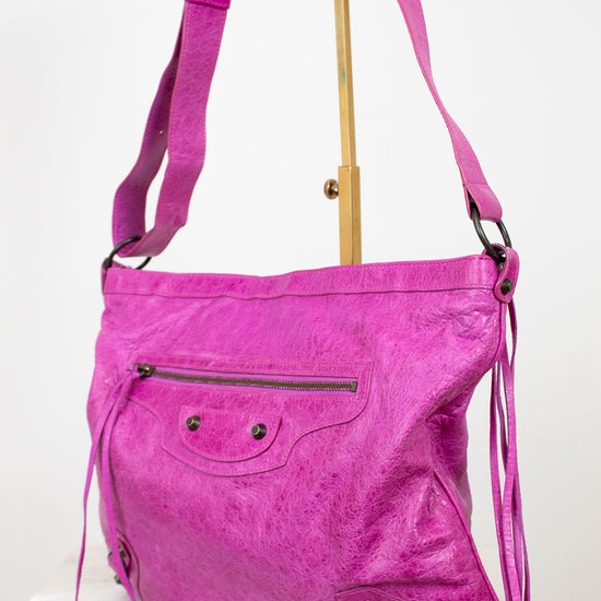 Pink shoulder bag with a strap on a white background