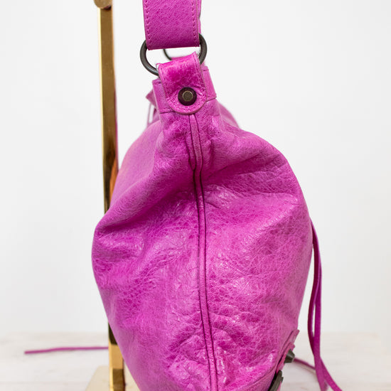 Purple leather bag with a strap on a white background