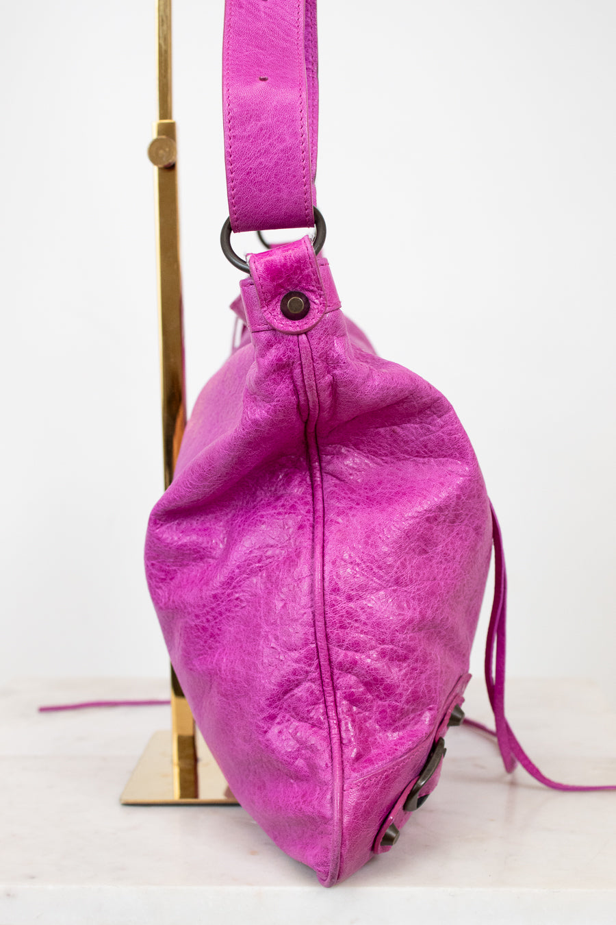 Purple leather bag with a strap on a white background