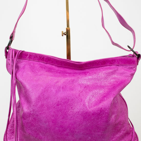 Purple handbag with a strap on a white background