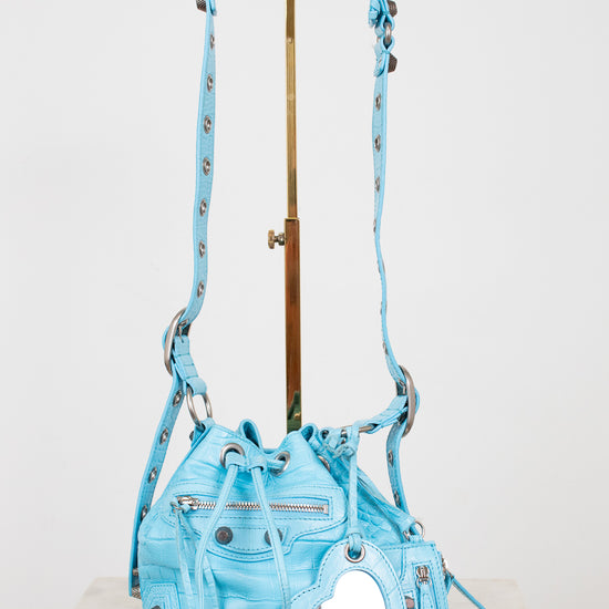Light blue handbag with decorative elements on a white background