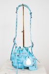 Light blue handbag with decorative elements on a white background