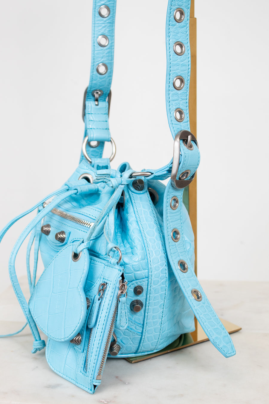 Light blue handbag with studded details on a white background