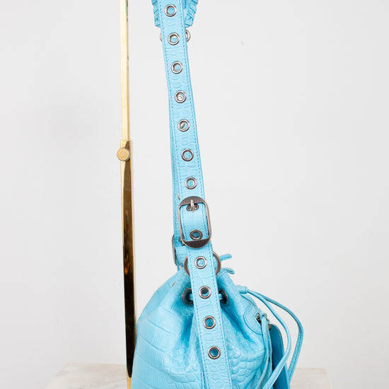 Light blue handbag with a strap on a white background
