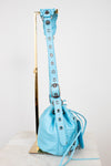 Light blue handbag with a strap on a white background
