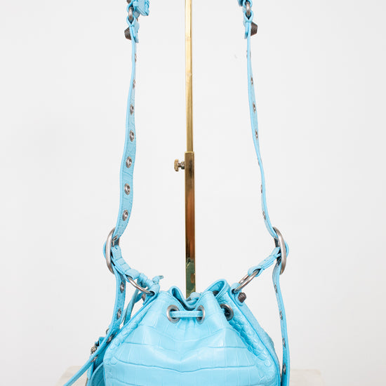 Light blue bucket bag with a strap on a white background