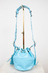 Light blue bucket bag with a strap on a white background