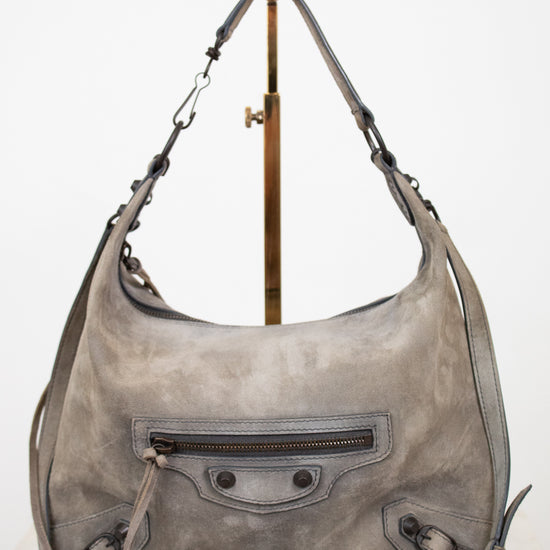 Gray leather shoulder bag with a strap on a white background