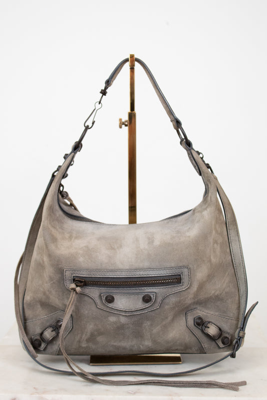 Gray leather shoulder bag with a strap on a white background