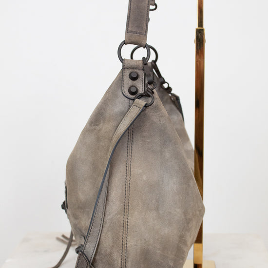 Gray shoulder bag on a gold stand against a white background