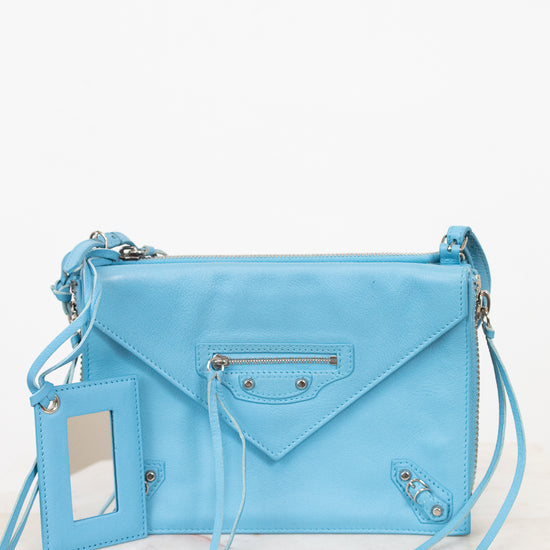 Light blue handbag with a strap on a white background