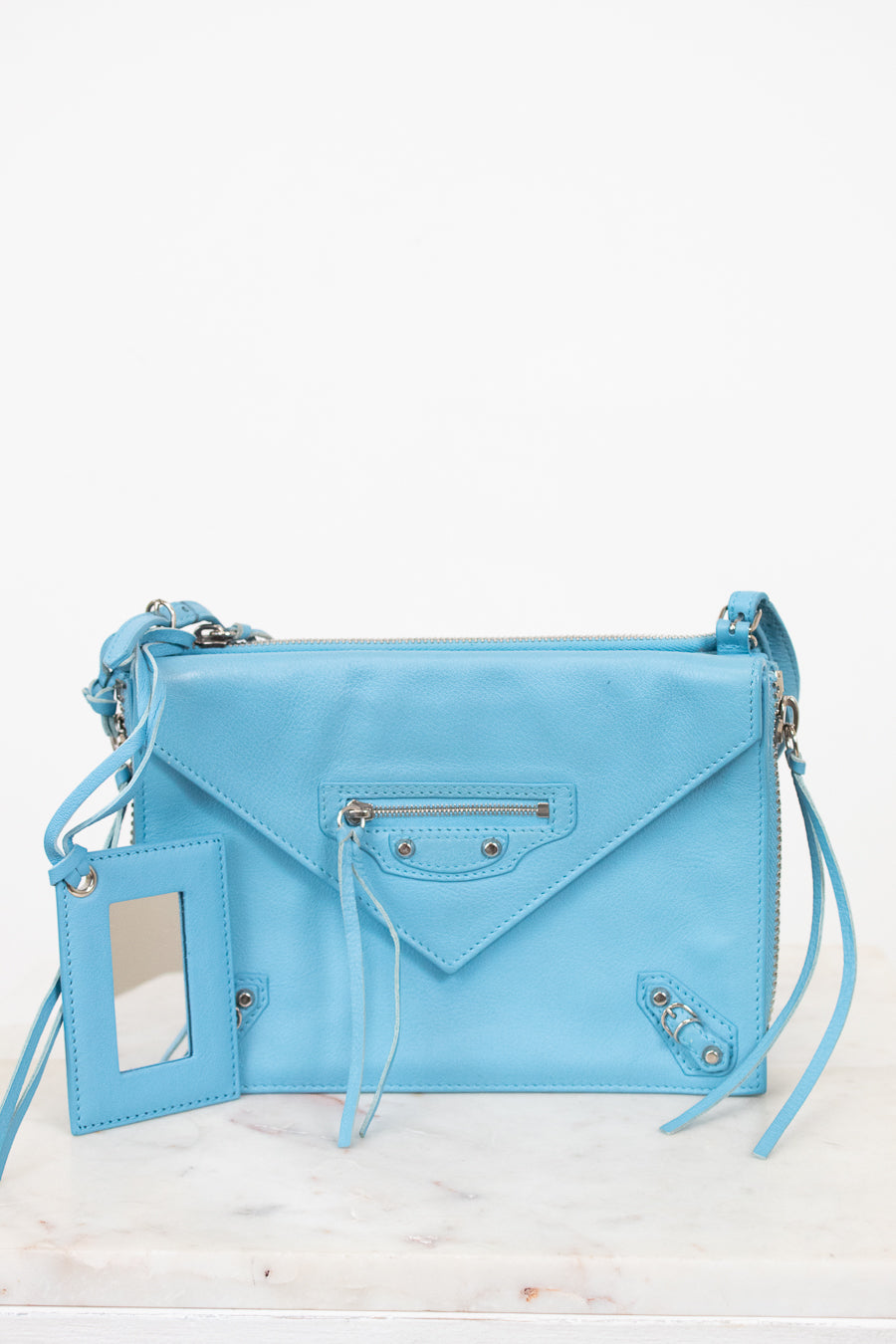 Light blue handbag with a strap on a white background