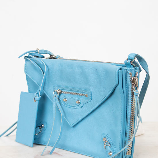 Light blue handbag with a matching mirror on a white background