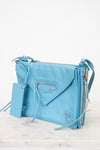 Light blue handbag with a matching mirror on a white background