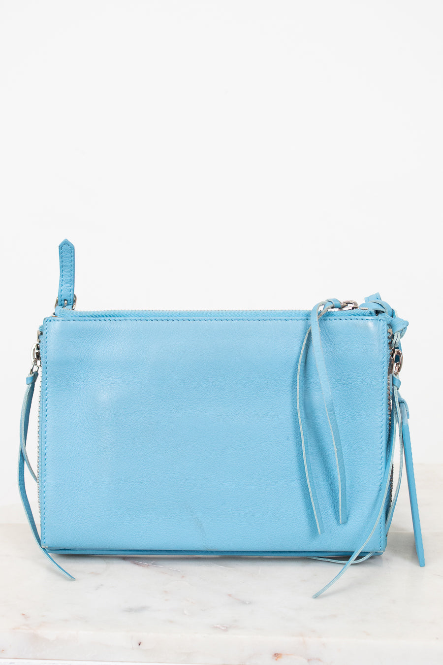 Light blue handbag with a strap on a white background