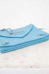 Light blue clutch bag on a marble surface