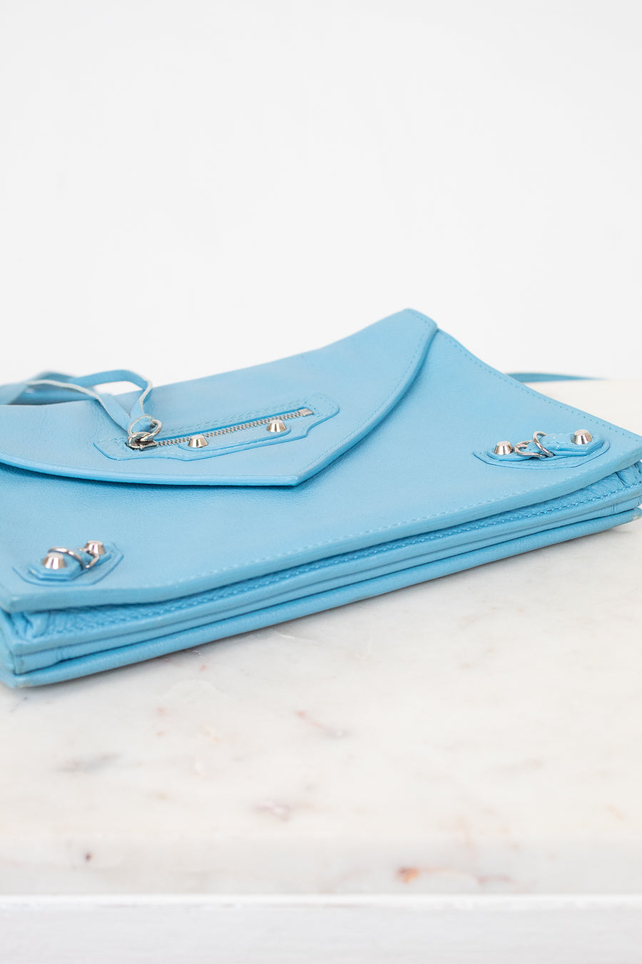 Light blue clutch bag on a marble surface