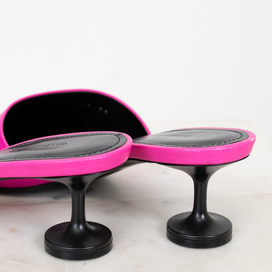 Pair of pink and black high heeled shoe on a white background