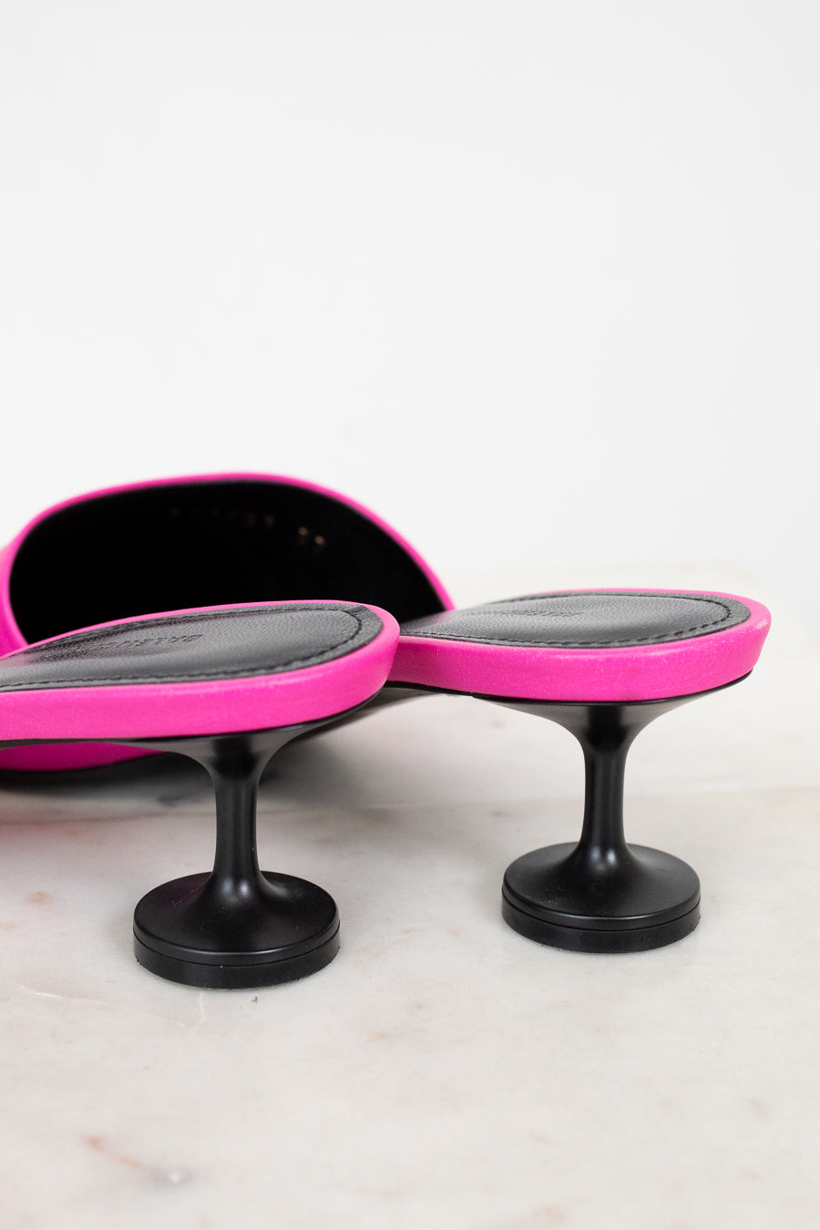 Pair of pink and black high heeled shoe on a white background