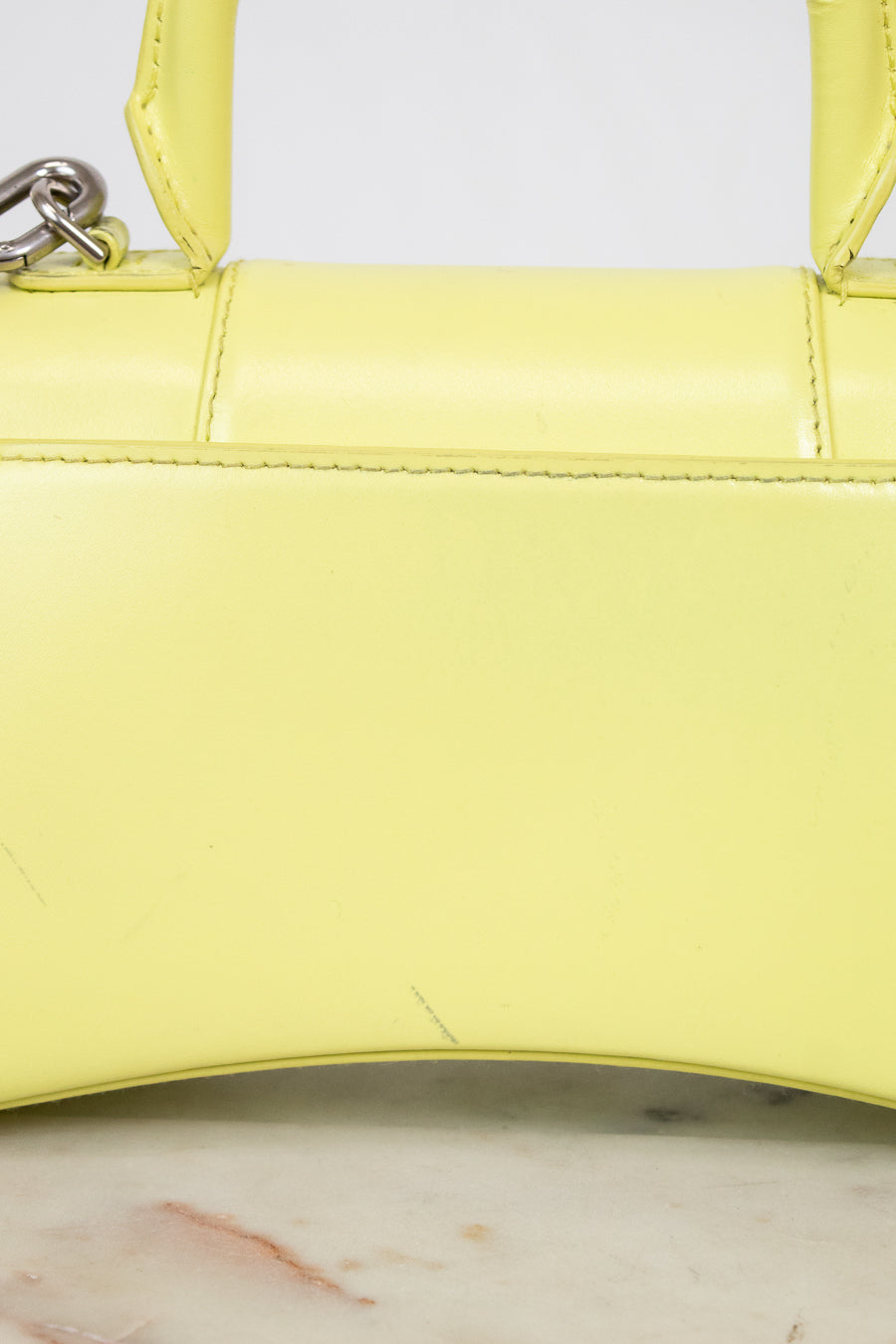 Close-up of a yellow handbag on a marble surface