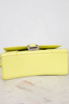 Yellow clutch bag on a light gray background