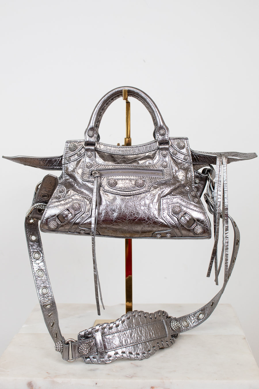 Silver handbag with intricate designs on a white background