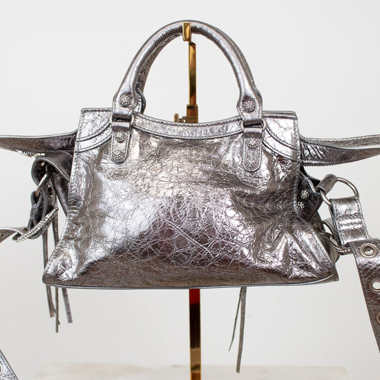 Back view of silver metallic crinkled texture handbag with detailed rhinestone accents on a light background